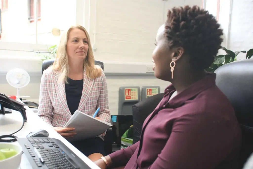 A specialist discussing workplace needs with a colleague